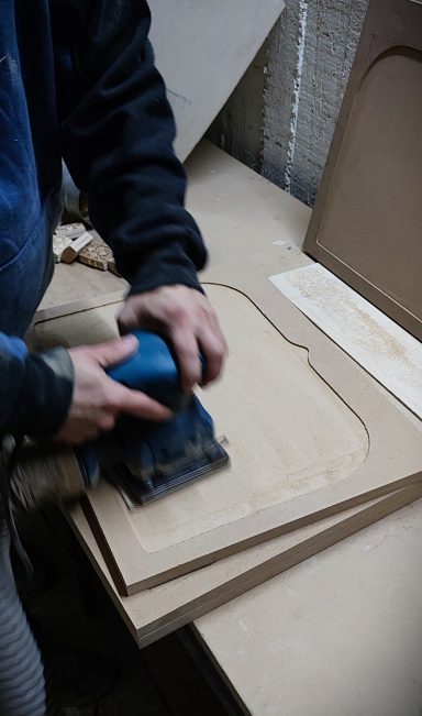Hand Sanding – Fine Surface Preparation Sanding wooden icon panels by hand for a smooth finish