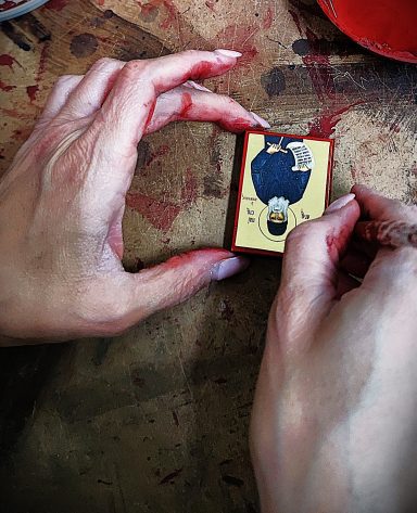 Precision Work on Mini Icon Hand positioning a small Byzantine icon during detailed finishing work